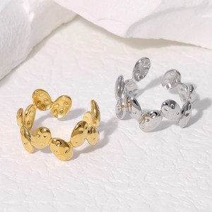Minimalist stainless steel hammered open rings in gold and silver on stone surface