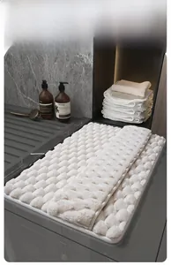 Detail of white memory foam bath mat featuring 3D spherical texture and quick-dry fabric