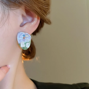 Detail of floral enamel vintage earrings featuring purple tones and faux pearl accents