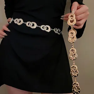 Elegant gold layered waist chain featuring interlocking rhinestone rings on a black dress