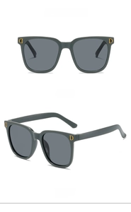 Détail de lunettes de soleil enfant gris foncé avec logo D doré et protection UV