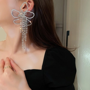Boucles d'oreilles nœud argenté avec pompons en cristal et strass étincelants