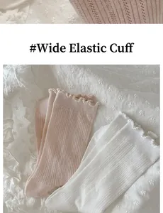 Detail of white and pink cotton socks featuring ruffle cuffs and high elasticity texture