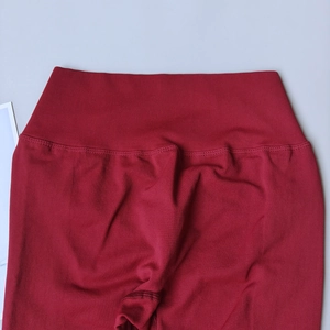Détail du pantalon de yoga rouge à taille haute montrant le tricot sans couture et les coutures