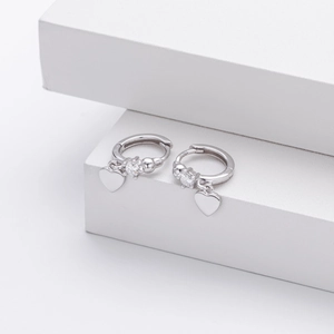 Detailed close-up of S925 silver heart earrings with sparkling cubic zirconia on white blocks