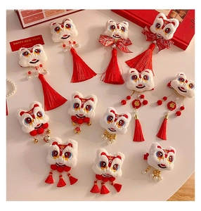 Detail of plush lion dance hair clips with red tassels and golden New Year bells