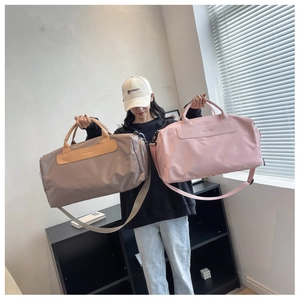 Close-up of khaki and pink nylon gym bags with adjustable straps and logo details