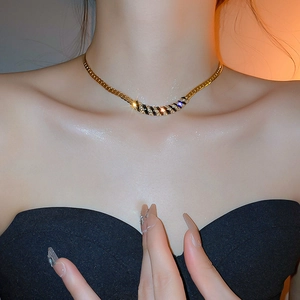 Elegant gold choker necklace with black enamel and zircons shown on model