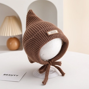 Close-up of brown pointed knit baby hat with chin straps and miu embroidery detail