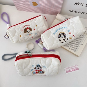 Detailed view of quilted pencil cases with cute puppy embroidery and red zippers