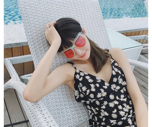Watermelon gel eye mask for cooling therapy used by a model at the poolside