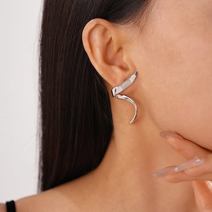 Close-up of minimalist silver spiral ear cuff with a polished finish on a model's ear