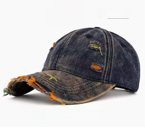Close-up of distressed denim baseball cap with orange frayed ripped holes and washed finish