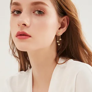 Elegant gold spherical chain tassel drop earrings for women worn by a model