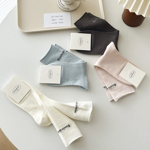 Four pairs of breathable knit mid-calf socks in cream, blue, pink, and grey colors