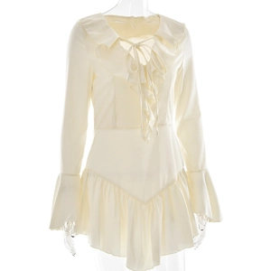 Détail d'une robe crème avec col à volants, laçage à l'avant et manches cloche