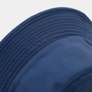 Detail of dark blue quick-dry bucket hat showing reinforced stitching on the brim