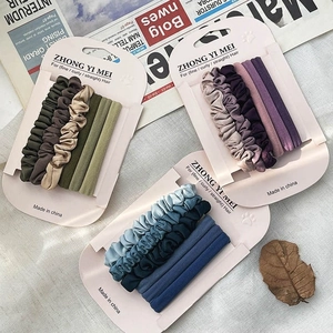 Elastische Macaron Stoff Haargummis Set in Grün, Lila und Blau auf Karten präsentiert