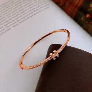 Rose gold plated zircon letter H bangle with mother of pearl inlay on leather display