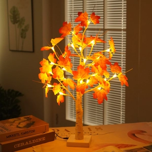 Detail of warm LED maple tree lamp with white birch texture base and orange leaves