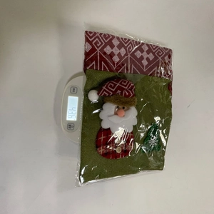 Détail montrant le poids d'un sac cadeau Père Noël en jute sur une balance à 43,6g