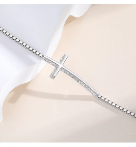 Detailed macro view of a 925 silver cross pendant with sparkling zircon stones and box chain