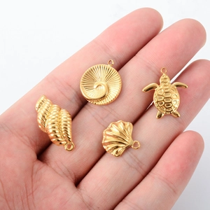 Golden stainless steel ocean pendants featuring seashell, conch, and sea turtle shapes