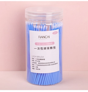 Detail of 100 disposable eyelash micro brushes in a clear storage jar for salon use
