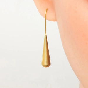 Macro detail of gold teardrop earrings showing high polish finish and elegant drape