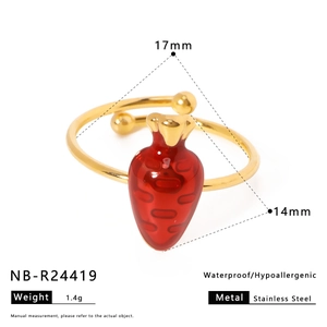 Macro view of gold stainless steel ring featuring a vibrant red enamel carrot design