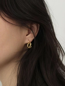 Minimalist 925 sterling silver knotted hoop earrings in gold worn by a model