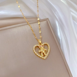 Titanium gold bear necklace with red-eye heart pendant on beige stand and silk