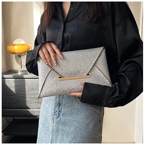 Détail macro d'une pochette pailletée argentée avec fermeture élégante en métal doré sur face