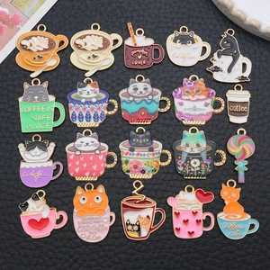 Detail view of 19 assorted colorful enamel coffee cup and cat charms on dark background