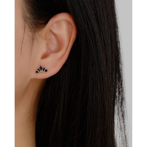 Macro side view of black zircon crown earrings on ear showing elegant 5-stone curved design