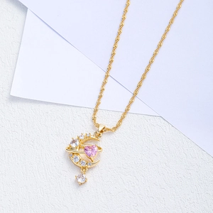 Close-up of pink heart zircon and moon pendant on a refined gold twist chain necklace