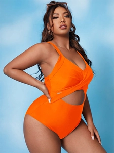 Detail of bright orange one-piece swimsuit featuring front cutout and wrap bodice