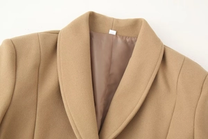 Close-up of a camel wool coat featuring notched lapels and smooth satin lining detail