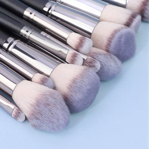 Close-up of professional makeup brushes with purple gradient bristles and silver ferrule