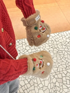Gros plan de mitaines en peluche marron avec broderie d'ours festif et pompons colorés