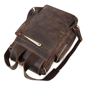 Close-up of vintage crazy horse leather backpack with metal zippers and phone pocket