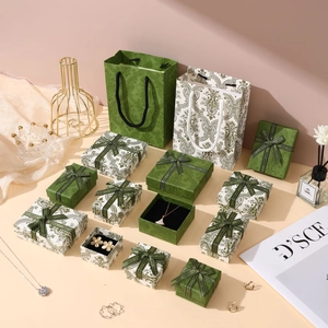 Detailed set of vintage green paisley jewelry boxes with ribbon bows and matching gift bags