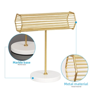 Detail of iron jewelry stand featuring gold metal frame and marble base texture