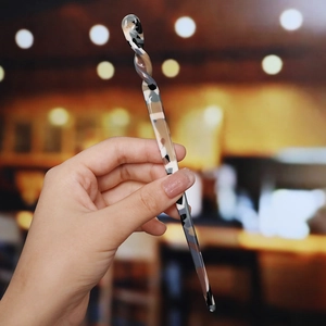 Macro detail of tortoiseshell acetate hair stick featuring a unique spiral twist design