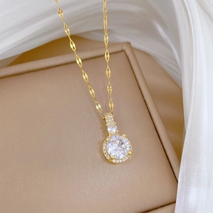 Collier de luxe plaqué or avec pendentif rond en zircon posé sur un coffret à bijoux