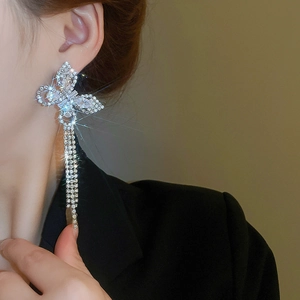 Detail of silver butterfly tassel earrings with sparkling rhinestones on model