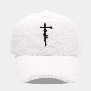 Close-up of white Sherpa baseball cap featuring black faith embroidery and cross detail