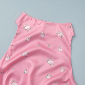 Close-up of pink satin fabric with delicate rose floral pattern and silky texture