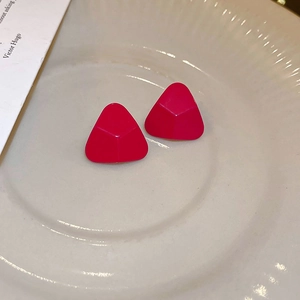 Boucles d'oreilles géométriques triangulaires rouge rose mat sur plat céramique