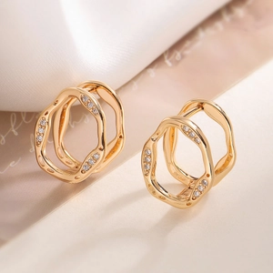 Irregular geometric zircon stud earrings in gold finish on minimalist background
